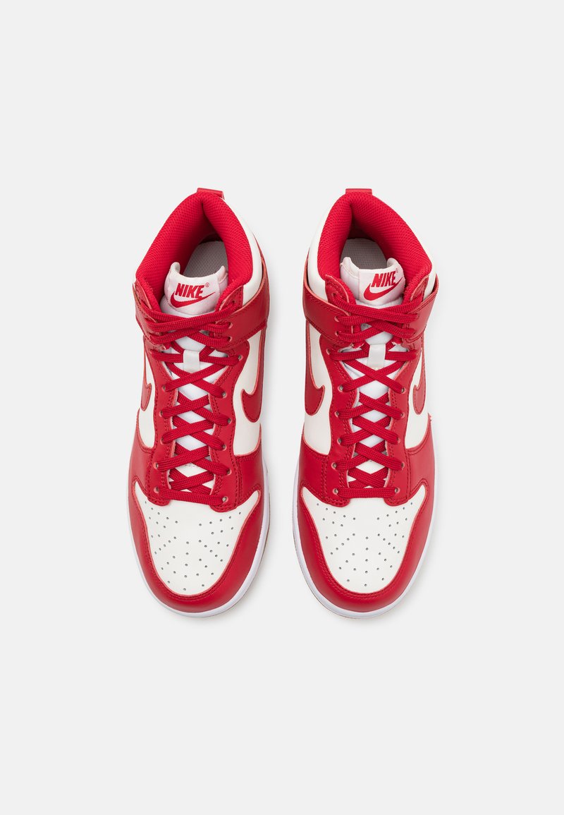 Baskets Nike rouges et blanches avec un design montante, en cuir et en maille, boîte à orteils perforée et logo swoosh bien en évidence.