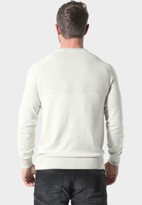 Helles graues, geripptes Sweatshirt mit strukturiertem Rücken, langen Ärmeln und schmalem Saum. Gefertigt aus weichem, gestricktem Stoff mit dezenten Details.