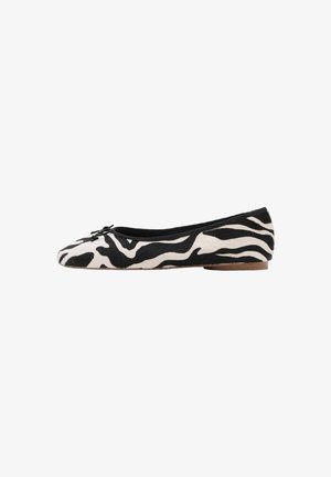 Ballerines à motif zèbre noir et blanc, en tissu texturé, avec un bout rond et une semelle plate et flexible.