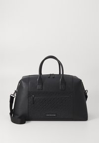 Sac de voyage noir en cuir texturé. Équipé de deux poignées et d'une bandoulière amovible. Comprend une poche zippée à l'avant et un accent logo.