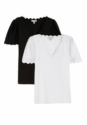 Topuri cu mâneci scurte alb-negru, cu decolteu în V și margini tivite în valuri, expuse suprapuse pe un fundal simplu.