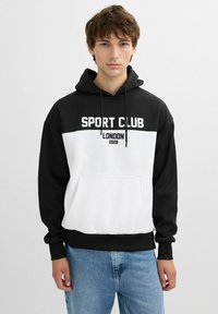Sudadera con capucha en blanco y negro con el texto "SPORT CLUB LONDON 2028". Cuenta con un bolsillo frontal, puños y dobladillo acanalados. Textura de tela suave.