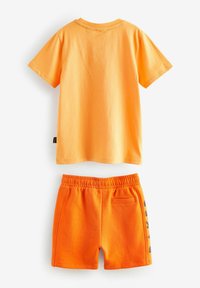 Orange bomulds T-shirt med rund hals og korte ærmer, parret med matchende orange shorts med elastisk talje og lomme.