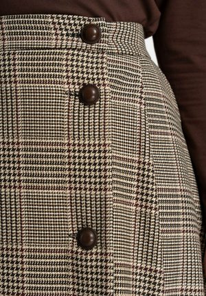 Spódnica w kratę w odcieniach beżu, brązu i kremu. Charakteryzuje się wysokim stanem, kontrastowymi brązowymi guzikami oraz teksturowanym materiałem z wzorem w zęby psa.