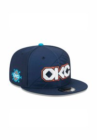 Casquette ajustée bleu marine avec logo "OKC" brodé en blanc et orange, bouton bleu clair sur le dessus et motif décoratif sur le côté.