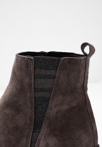 Tmavě šedé semišové kotníkové boty s hladkým povrchem, elastickými bočními panely a poutkem na zadní straně.