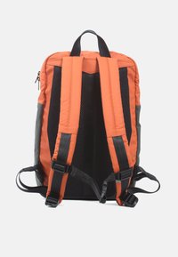 Rugzak met oranje gewatteerde voorkant, zwarte netbanden, grijze zijaccenten en meerdere verstelbare banden aan de achterkant voor comfort en ondersteuning.