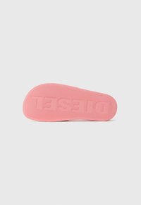 Roza gumijasta podplat čevlja z teksturiranim oprijemom, ki ima rahlo ukrivljeno obliko in vtisnjen napis "TESSEL" na spodnji strani.