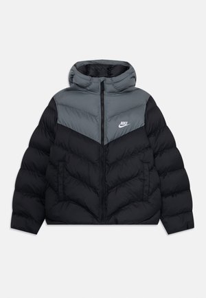 Doudoune Nike noire et grise avec capuche, fermeture éclair intégrale à l'avant, poches latérales, et logo sur un panneau de poitrine gris.
