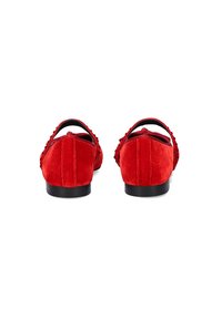 Zapatos de terciopelo rojo con un talón redondeado, superficie texturizada, tira en el tobillo y una suela negra sólida. Presentan un detalle con bordes ondulados cerca del tacón.