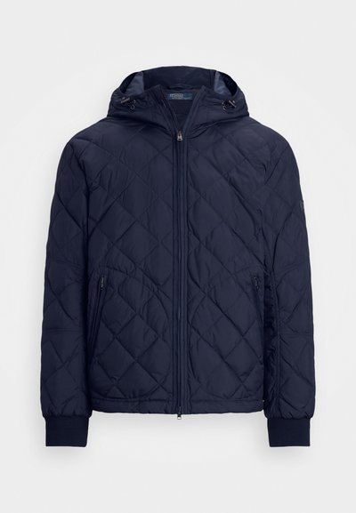 Tamsiai mėlyna siūta striukė su kapišonu, su priekiu užtraukiama užtrauktuku, dviem šoniniais kišenėmis ir guminiu kanteliu rankogaliuose, kad užtikrintų papildomą patogumą ir šilumą.