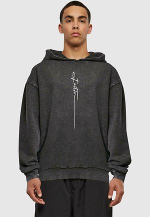 Dark gray hoodie made from textured fabric, featuring a loose fit, a drawstring hood, and white handwritten-style text on the front.