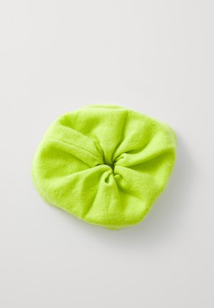 Neon green fabric scrunchie with a soft texture and gathered design, featuring a central knot. Shape is circular and elastic.
