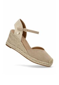 Sandalia de cuña de esparto beige con parte superior de tela texturizada, puntera cerrada, tira en el tobillo y plataforma de yute trenzado con borde redondeado.