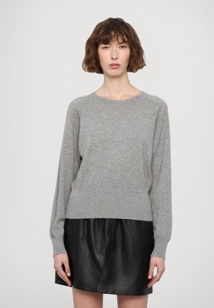 Hallide hall pullover, millevarvusega, pika varrukaga ja ümmarguse kaelusega. Kootud tekstuur, vabalt langev lõige. Kombineeritud musta nahast seeliku juurde.