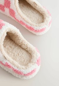 Soejad sussid pehme beeži voodriga ja vahelduvate roosade ning valgete triipudega välimisel küljel, mis tagavad hubase tunde.