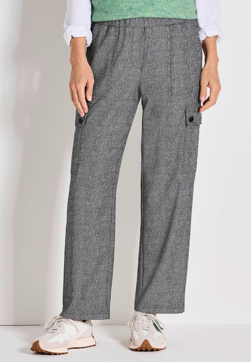 Grau gemusterte Cargo-Hosen mit lockerer Passform, ausgestattet mit Seitentaschen und einem dehnbaren Bund, kombiniert mit weißen und beigen Turnschuhen.