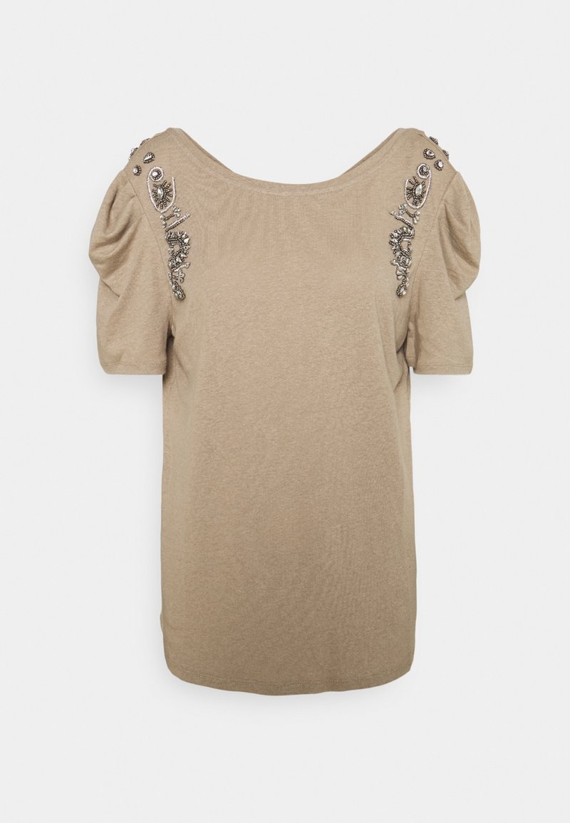 Haut beige à manches courtes avec manches bouffantes et broderie de perles décorative le long des coutures d'épaule.