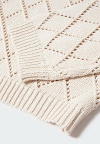 Pull beige en maille avec un motif en losange, doté de poignets et d'un ourlet côtelés. La texture semble douce et épaisse, idéale pour superposer.