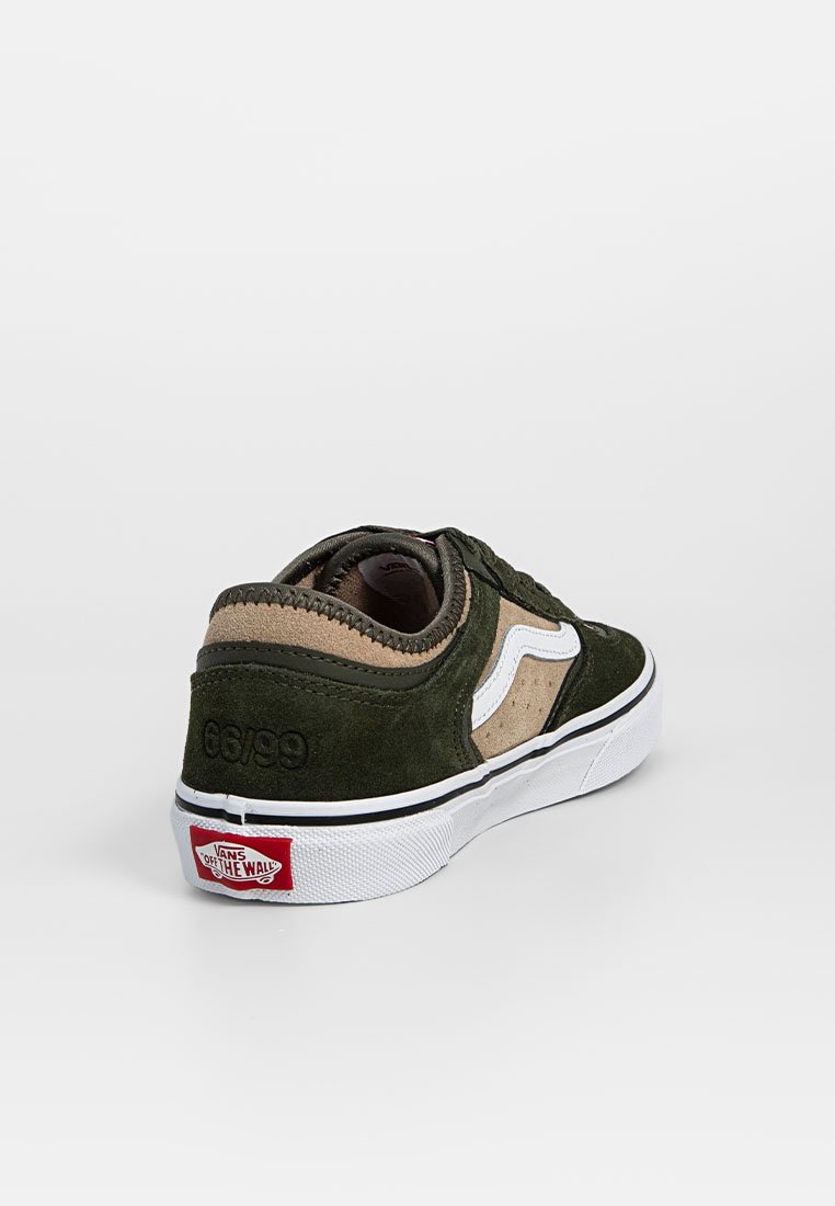 Zapatillas de ante verde y beige con acentos blancos, puntera redonda, diseño de cordones y suela de goma. Presentan la marca "Vans Off the Wall".