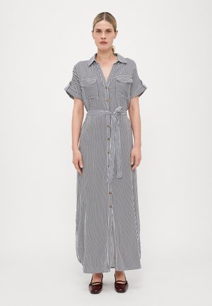 Striped maxi dress with short sleeves, button-down front, two chest pockets, and a tied waistbelt, in black and white colors, smooth fabric.
