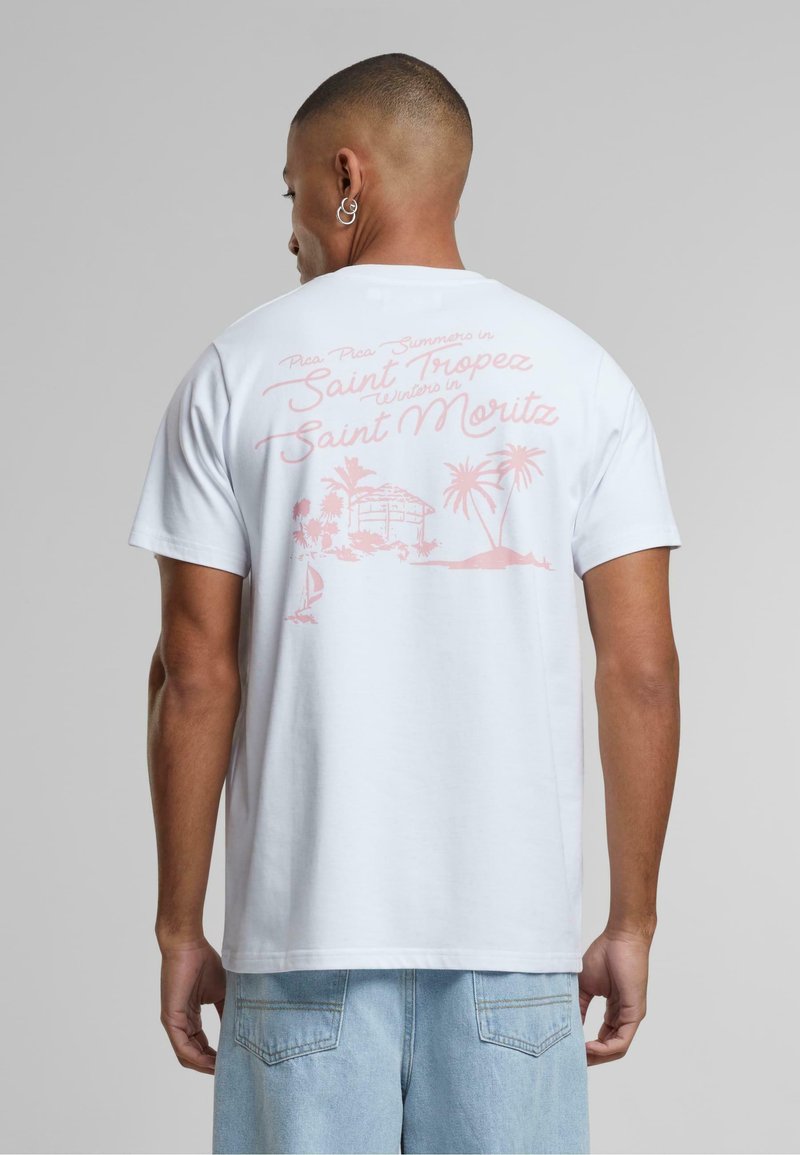 Bijela majica s kratkim rukavima koja na leđima ima ružičasti grafički tekst i tropsku sliku, s opuštenim krojem i klasičnim okruglim izrezom.