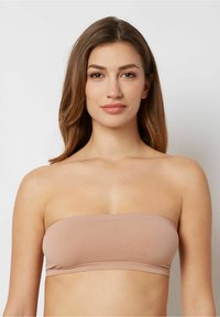Bandeau-top i lys beige stof, sømløs design med en glat tekstur, der har en tætsiddende form uden synlige lukninger eller udsmykninger.