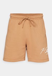 Short marron clair avec cordon de serrage et taille élastique, texte blanc en cursive sur la partie inférieure droite de la jambe, présenté sur un fond uni.