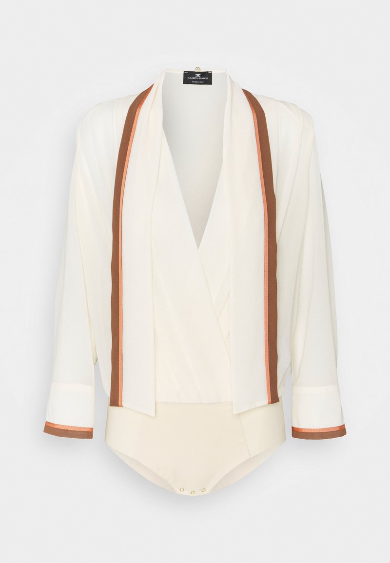 Vit blus med en inslagningdesign, bruna och orange randiga accenter. Har trekvartslånga ärmar och en tryckknappsstängning längst ner.