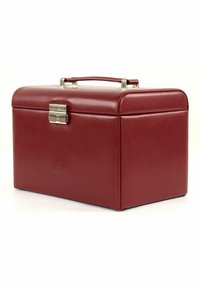 Boîte en cuir rouge avec fermeture à clip et poignée, présentant une texture lisse et une forme rectangulaire. Logos embossés sur le devant.