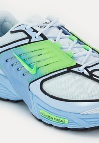 Ljusblå sportskor med ovandel av mesh, gröna plastdetaljer, svarta detaljer och en sula där "FULL LENGTH NIKE AIR" är märkt.