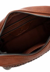 Borsa in pelle marrone con zip argentata aperta, che mostra l'interno foderato di scuro e una tasca interna con zip.