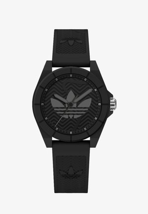 Montre en caoutchouc noir avec un bracelet en silicone texturé, boîtier octagonal et un cadran noir à motifs comportant un logo et des accents argentés.