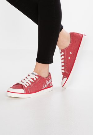 Röda kanvas sneakers med vita snören, gummitåhätta och vit sula. Med stiliserad text på sidan och kontrasterande sömmar.