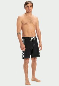 Μαύρα σορτς κολύμβησης με λευκές ραφές, διαθέτοντας ένα καρό μοτίβο στη μία πλευρά. Κατασκευασμένα από γρήγορα στεγνώνουν υλικά, σχεδιασμένα για άνεση.