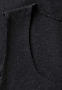 Schwarzes Tanktop mit weitem Ausschnitt und ärmellosem Design. Der Stoff ist glatt mit einer weichen Textur und minimalen Nähdetails.