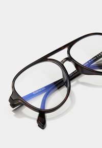 Occhiali tartaruga marroni con lenti trasparenti e braccia interne di colore blu, caratterizzati da un design della montatura arrotondata e dettagli metallici.