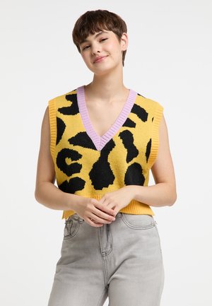 Vest tricotat galben cu imprimeu leopard negru, design în formă de V și guler ribat lilac. Mâneci scurte și croială lejeră. Blugi din denim gri ca bază.