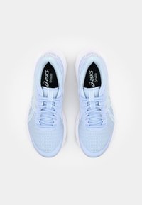 Zapatillas deportivas de color azul claro con parte superior de malla, cordones planos y suela acolchada. Presenta un logo sutil en el forro interior y acentos laterales.