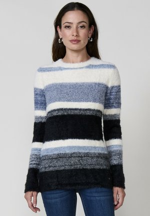 Suéter a rayas con textura suave y esponjosa en tonos de azul, blanco y negro. Cuello redondo y mangas largas, con un corte relajado.