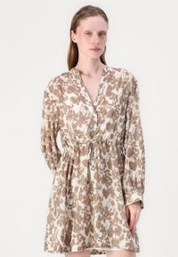 Abito a maniche lunghe in un leggero tessuto con stampa animale color crema e marrone, con scollatura a V, dettagli con bottoni e vita cintrata con cordoncino.
