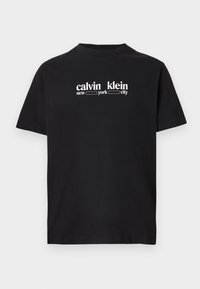 Juoda trumpomis rankovėmis marškinėliai su baltu tekstu „calvin klein new york city“ įrėmintu krūtinėje.