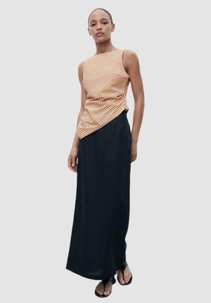 Striped orange and white sleeveless top paired with a long black skirt. The top features an asymmetrical cut and textured fabric.