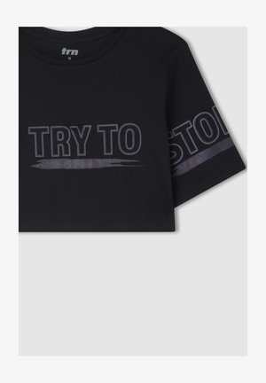 Czarny krótki t-shirt wykonany z bawełny, z krótkimi rękawami. Na przodzie i rękawie widnieje wyrazisty, odblaskowy napis "SPRÓBUJ MNIE ZATRZYMAĆ".