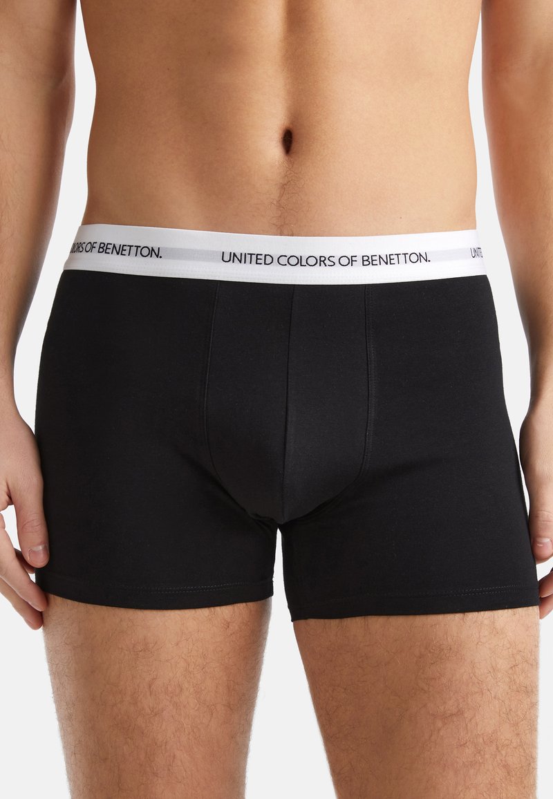 Czarne bawełniane spodenki w kształcie trunks z białą elastyczną talią z logo "UNITED COLORS OF BENETTON", gładka tekstura, dopasowany krój.