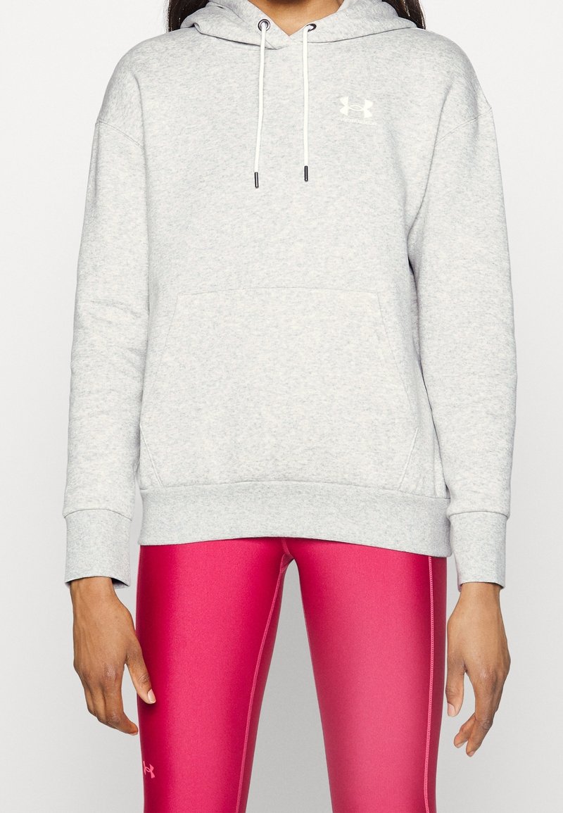 Ljusgrå hoodie i fleece med en framficka, justerbar snörning i huvan och vit logotyp på bröstet. Matchad med rosa leggings.
