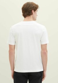 Weißes Baumwoll-T-Shirt mit kurzen Ärmeln, Rundhalsausschnitt und lässiger Passform. Keine sichtbaren Muster oder Grafiken, schlichtes Design.