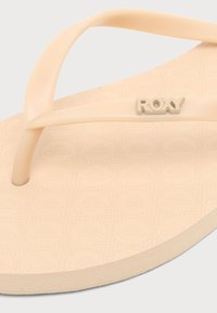 Μπεζ σαγιονάρες Roxy με υφή στη σόλα και λογότυπο στο λουράκι, κοντινή όψη στο μπροστινό και κεντρικό τμήμα.