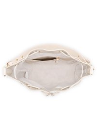 Valkoinen beigetote-laukku, jossa on sileä nahkapinta, avoin yläosa, säädettävät olkahihnat ja sisällä vetoketjullinen osasto. Teksturoitu vuoraus.