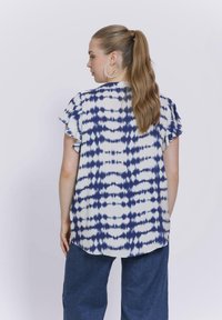Kurzärmlige Bluse im blau-weißen Batikmuster, mit lockerer Passform und abgerundetem Saum, aus leichtem Stoff gefertigt.